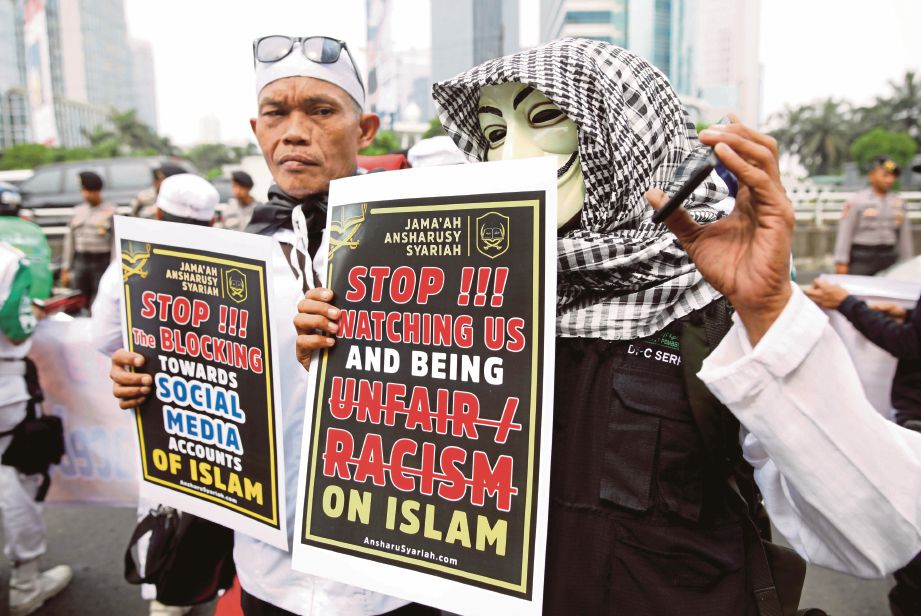 PENUNJUK perasaan membawa poster ketika memprotes di luar ibu pejabat Facebook di Jakarta. - Reuters  