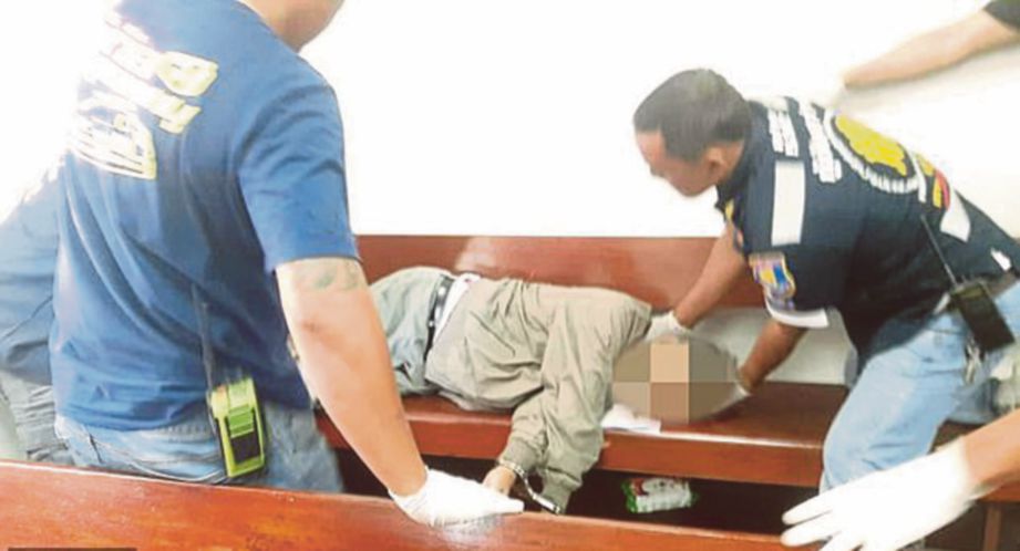ANGGOTA paramedik memeriksa mayat Thanin selepas dia maut ditembak polis di dalam mahkamah. FOTO Agensi