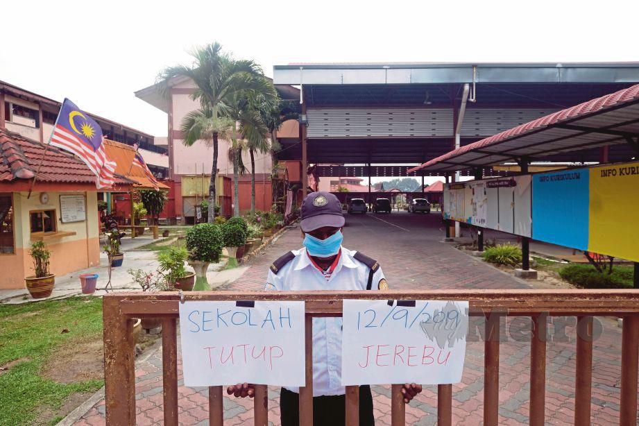 PENGAWAL sekolah SK Kampung Johan Setia, K Baskaran menunjukkan notis penutupan sekolah susulan jerebu.