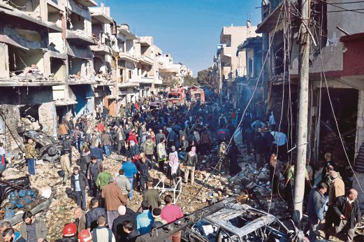 PENDUDUK berkumpul di lokasi serangan bom kereta di Homs, semalam.