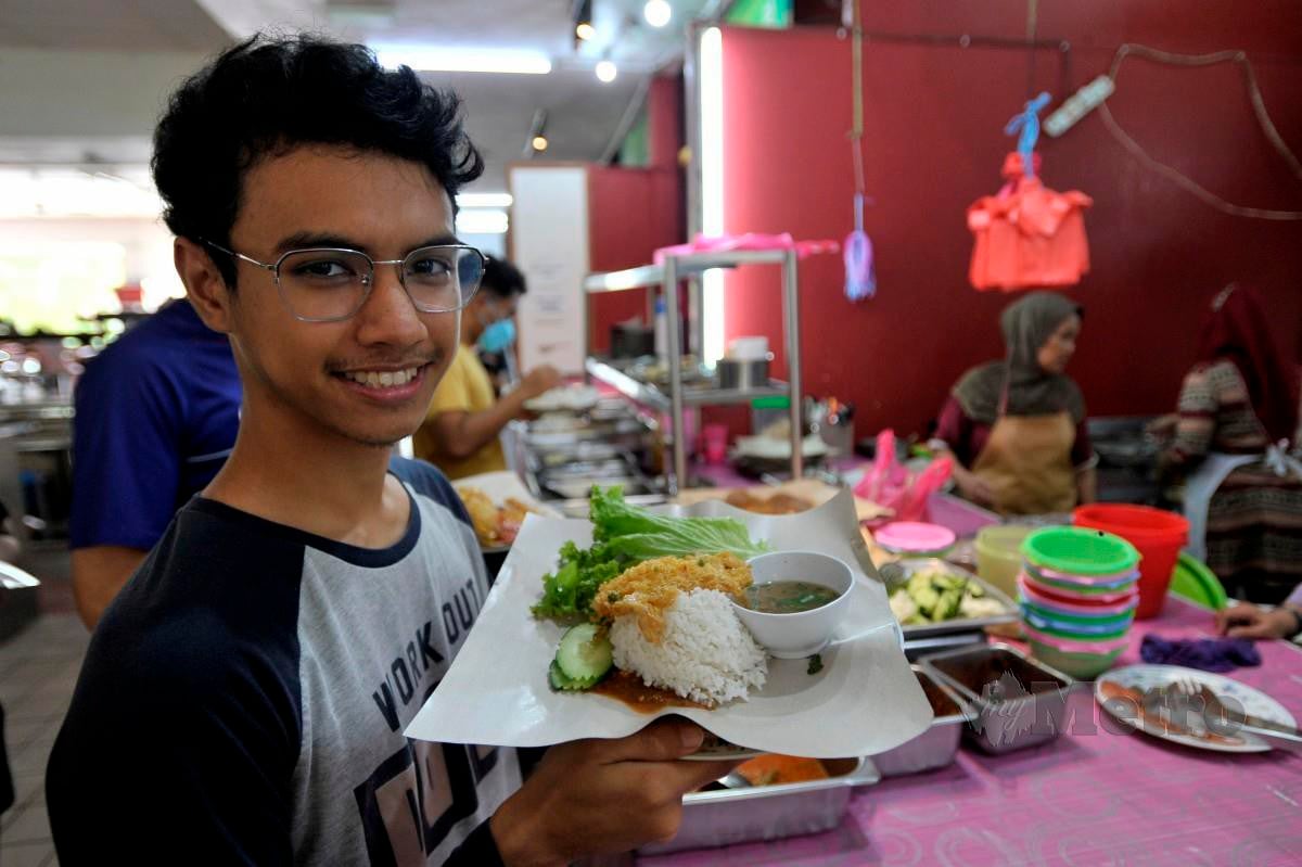 Pelajar Ijazah Sarjana Muda Linguistik Bahasa Inggeris, Mohamad Fikri Mohamad Fairus 21, menunjukkan menu makanan yang berharga RM3.50 ketika tinjauan Menu Keluarga Malaysia di Universiti Putra Malaysia, Serdang. FOTO AIZUDDIN SAAD