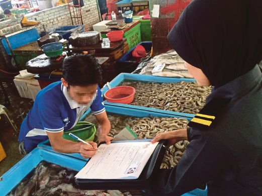 PEGAWAI  penguat kuasa     memeriksa premis yang mempamerkan tanda harga barangan di Pasar Borong Selangor,  Seri Kembangan.