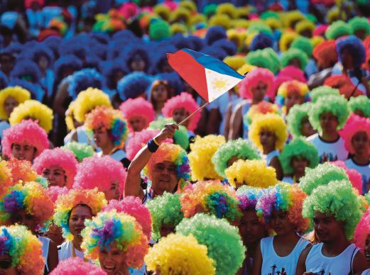 PELARI memakai rambut palsu berwarna-warni ketika mengambil bahagian dalam acara ‘Larian Warna Kebebasan’ sempena Hari Kemerdekaan Filipina di Bandar Taguig, selatan Manila, semalam.