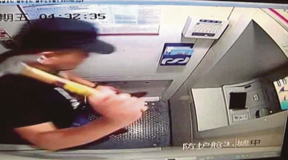RAKAMAN kamera keselamatan menunjukkan Cai cuba memecahkan sebuah mesin ATM menggunakan tukul tetapi gagal. - Agensi
