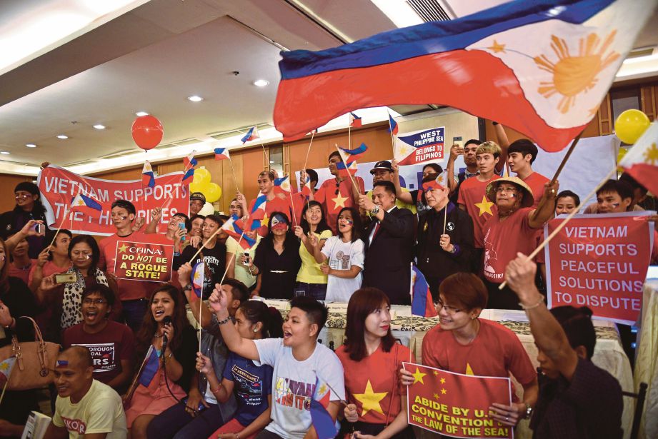 AKTIVIS Filipina dan rakyat Vietnam menyambut baik keputusan tribunal antarabangsa mengenai Laut China Selatan di Manila, semalam. - AFP