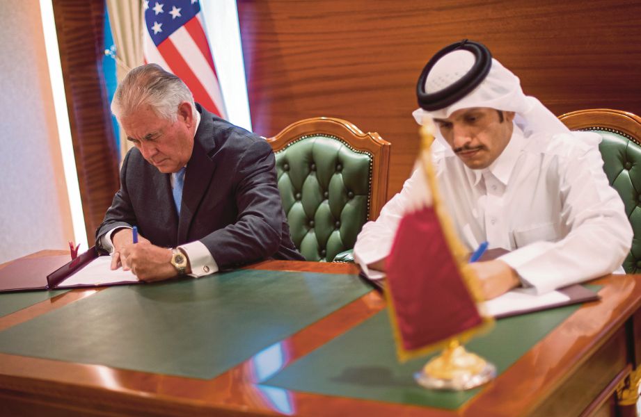 TILLERSON (kiri) menandatangani perjanjian memerangi keganasan dengan Menteri Luar Qatar, Sheikh Mohammed bin Abdulrahman Al Thani di Doha, kelmarin.  - EPA