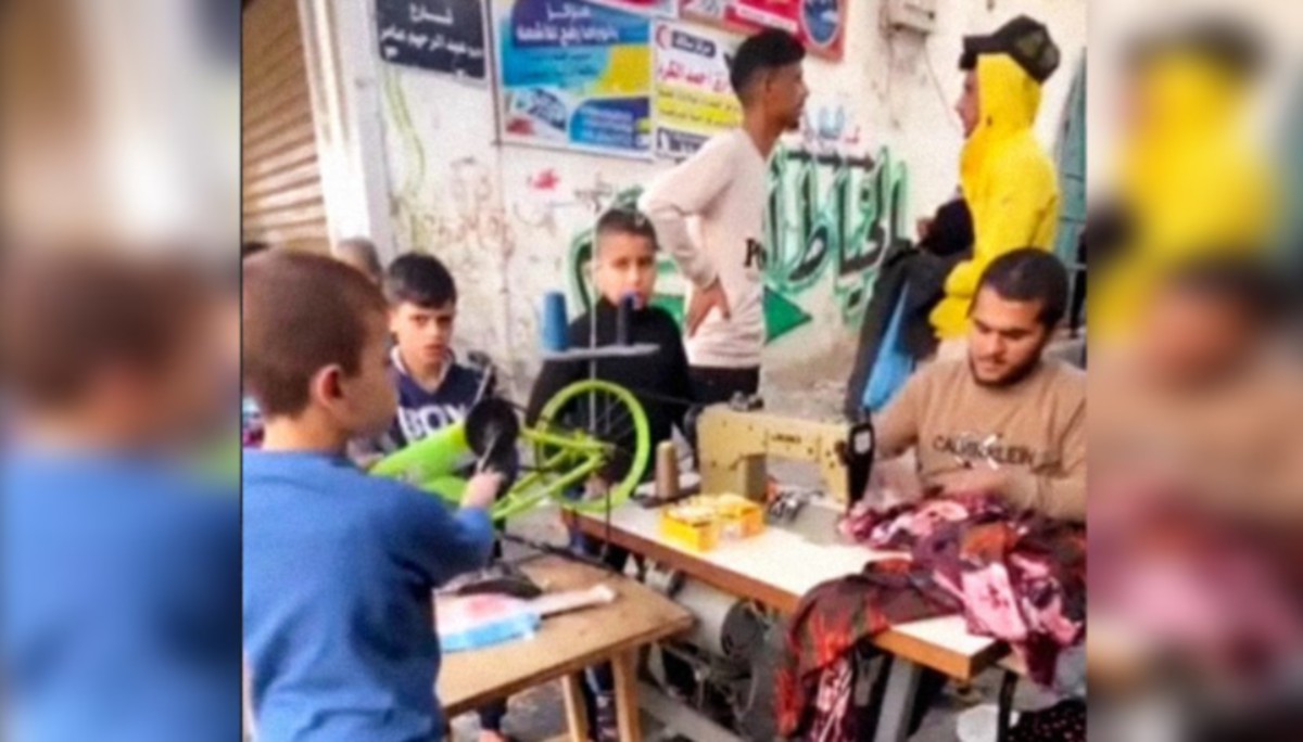 PENDUDUK Gaza menjahit baju sejuk dengan mesin jahit yang dihidupkan dengan tenaga elektrik daripada basikal. FOTO Agensi.