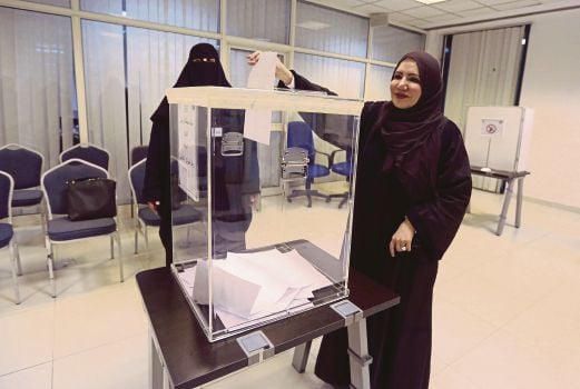 SEORANG wanita memasukkan kertas undi ke dalam peti undi di Riyadh, semalam.