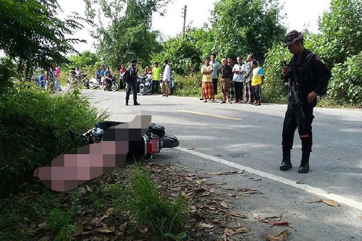 SEORANG tentera memerhatikan mayat seorang lelaki yang ditembak mati di Pattani.  