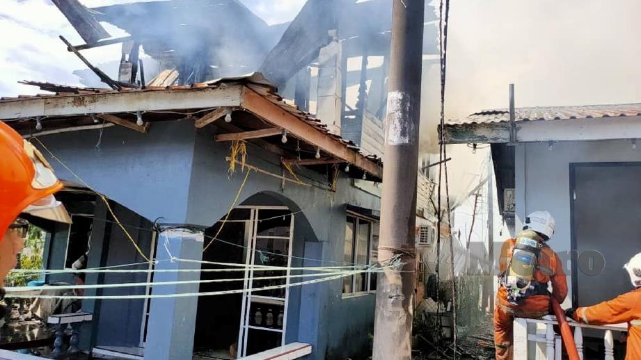ANGGOTA bomba mengawal kebakaran empat rumah di Kampung Tabuan Melayu. FOTO ihsan Bomba