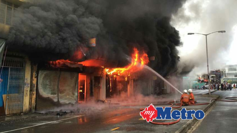 ANGGOTA bomba bertungkus lumus memadam kebakaran di Jalan Stephen Tan, Tawau. FOTO Abdul Rahemang Taiming 