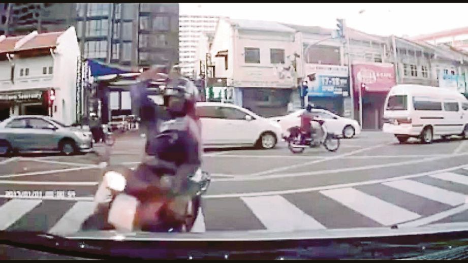 RAKAMAN kamera  menunjukkan penunggang motosikal membaling batu pada cermin hadapan kereta mangsa.  