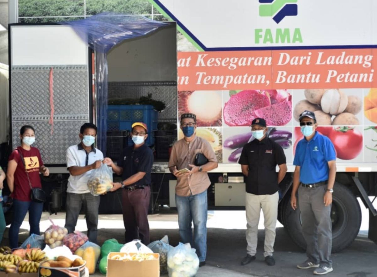 RIBIN (tiga kiri) menerima sumbangan bahan makanan daripada wakil ladang kontrak untuk diagihkan kepada penduduk di kawasan PKPD. FOTO ihsan Fama Sabah