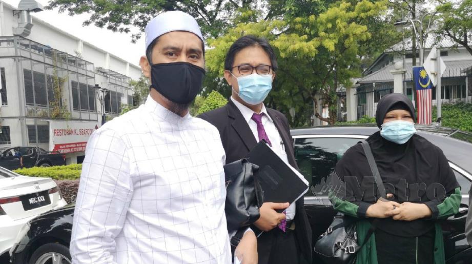 Mohd Asri (kiri) ketika hadir di Bukit Aman, hari ini.