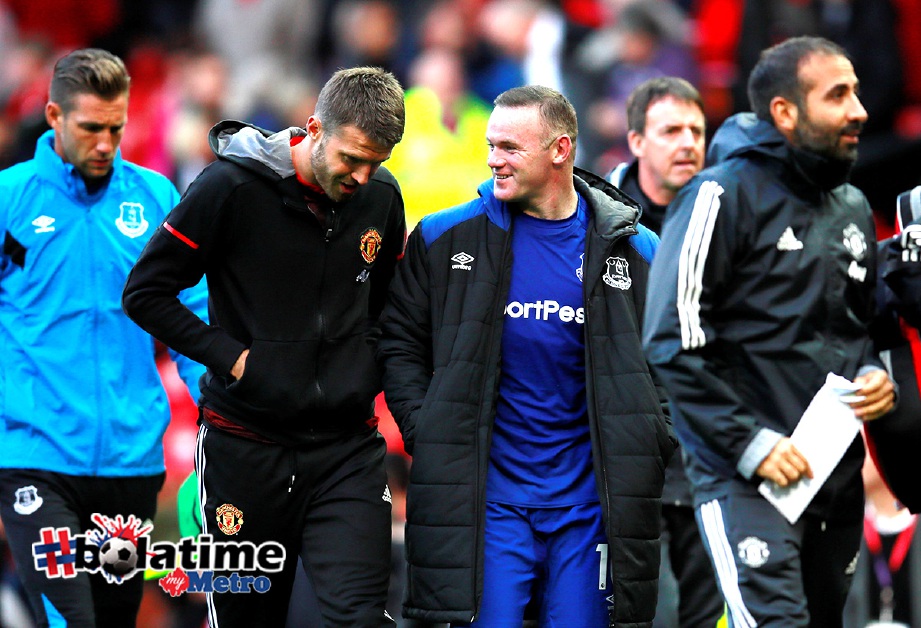 ROONEY (kiri) berborak dengan pemain United Michael Carrick selepas permaianan tamat. -Foto Reuters