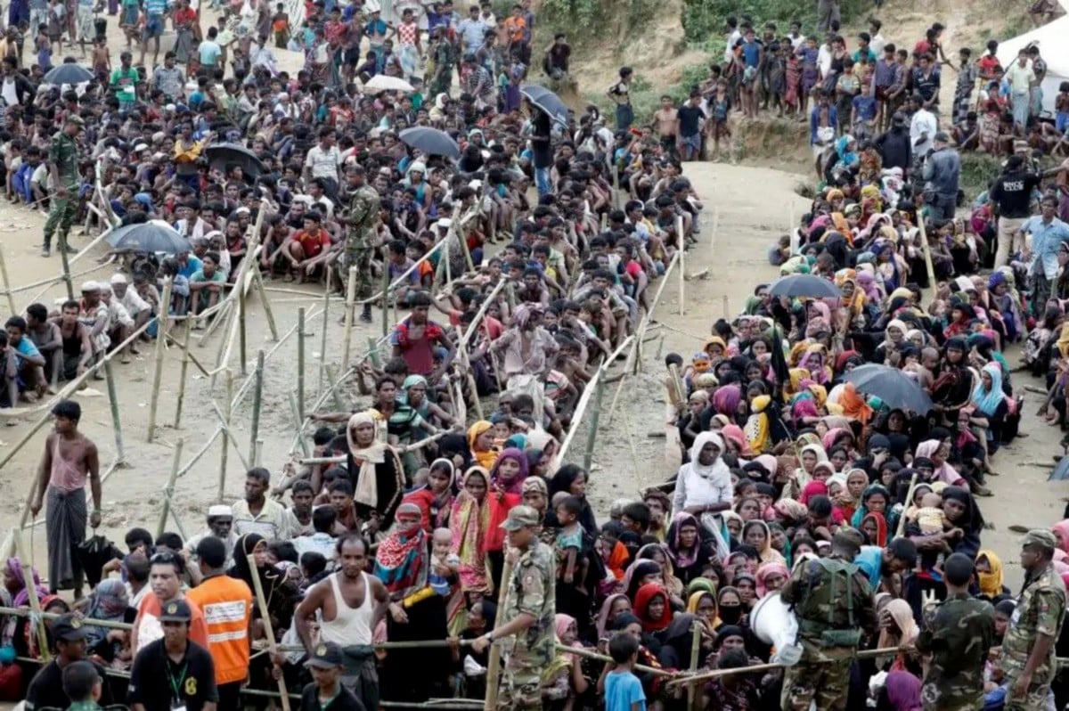 PELARIAN Rohingya dikawal tentera Bangladesh menunggu untuk menerima bantuan di Cox's Bazar. - Foto Reuters