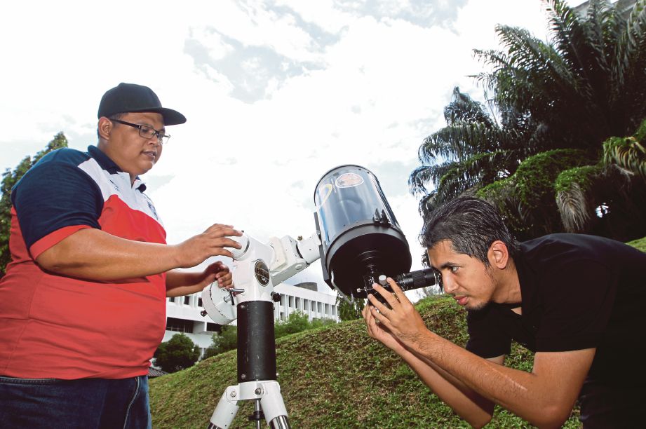 Mohd Rashidi (kanan) bersama Pembantu Hal Ehwal Islam Jabatan Mufti Negeri, Khairul Anuar Shamsuddin memeriksa teleskop yang akan digunakan untuk melihat ‘Lunar Pedigee’, malam ini. 