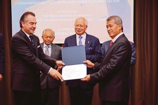 Najib menyaksikan Azman (kanan) menerima sijil saham daripada Ozozan sambil disaksikan Leo Moggie.