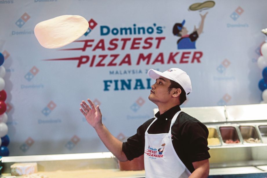 Aksi membuat piza oleh Penolong Pengurus Daerah Cawangan The Weld dan Dang Wangi, Muhamad Firdaus Zainal pada pertandingan membuat piza terpantas Domino's Pizza