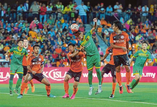 PENYERANG Kedah, Ahmad Fikri Saarani (tengah) menanduk ke arah pintu gol ketika menentang Felda United.