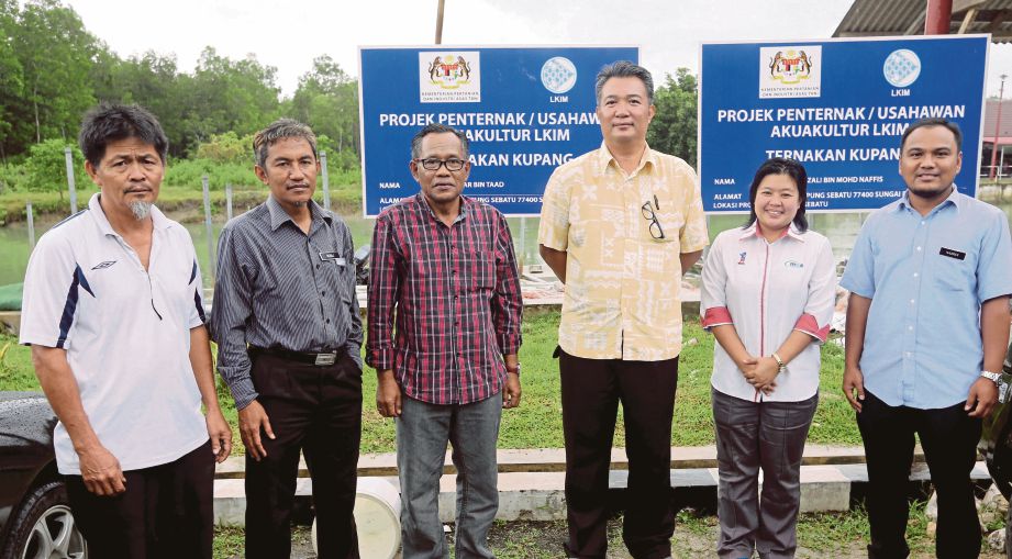 ROSLI (dua dari kiri) bersama Rapingeai (kiri) hadir di tapak projek penternak dan usahawan akuakultur LKIM ternakan kupang di Jeti Kuala Sebatu, Sungai Rambai.