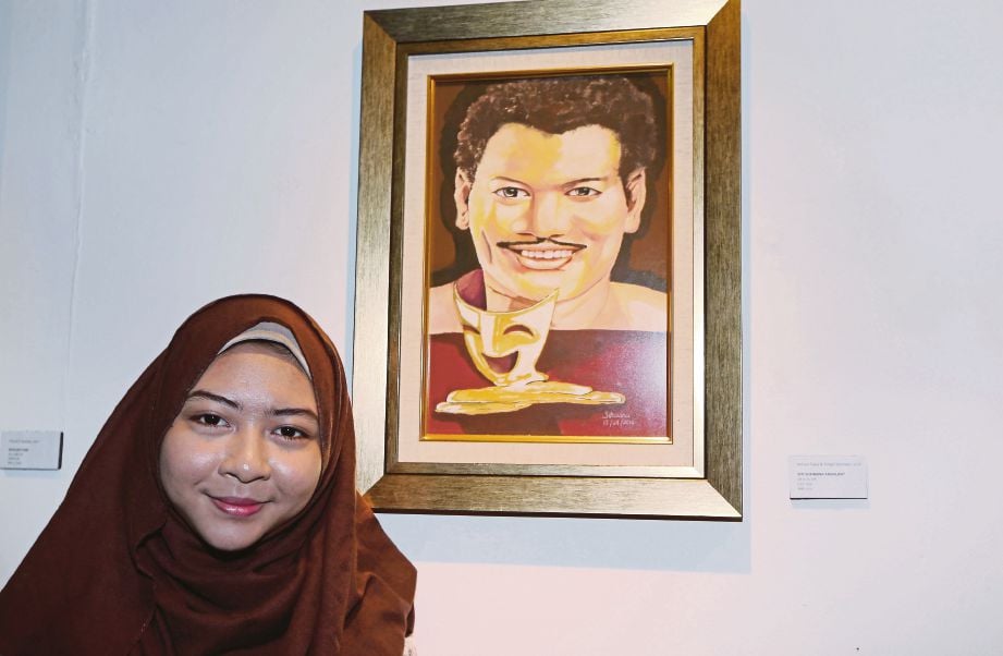 Siti Suhaana bersama potret P Ramlee yang dihasilkannya dipamerkan   di Galeri ASWARA.