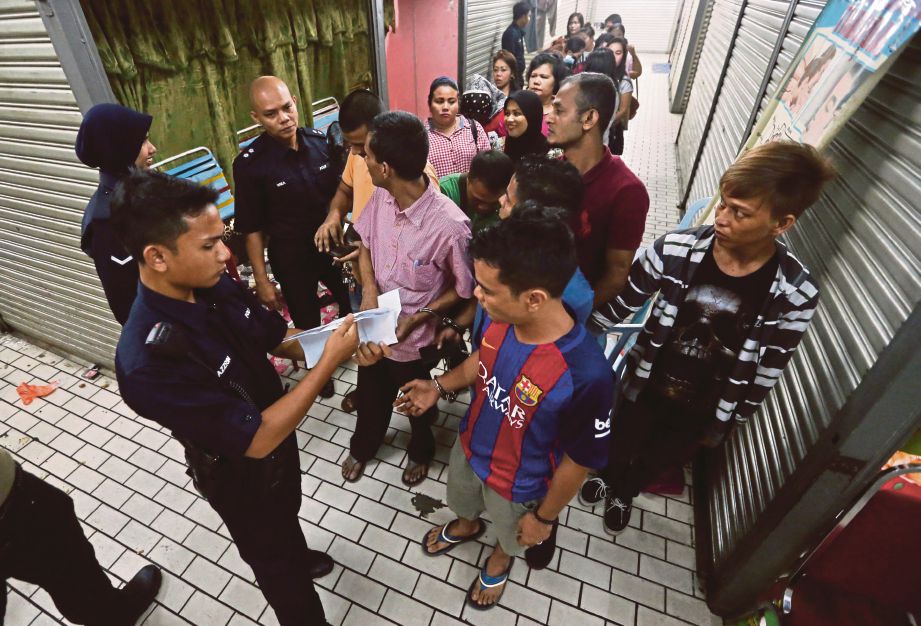 ANGGOTA polis memeriksa dokumen perjalanan warga asing di sekitar Chow Kit.