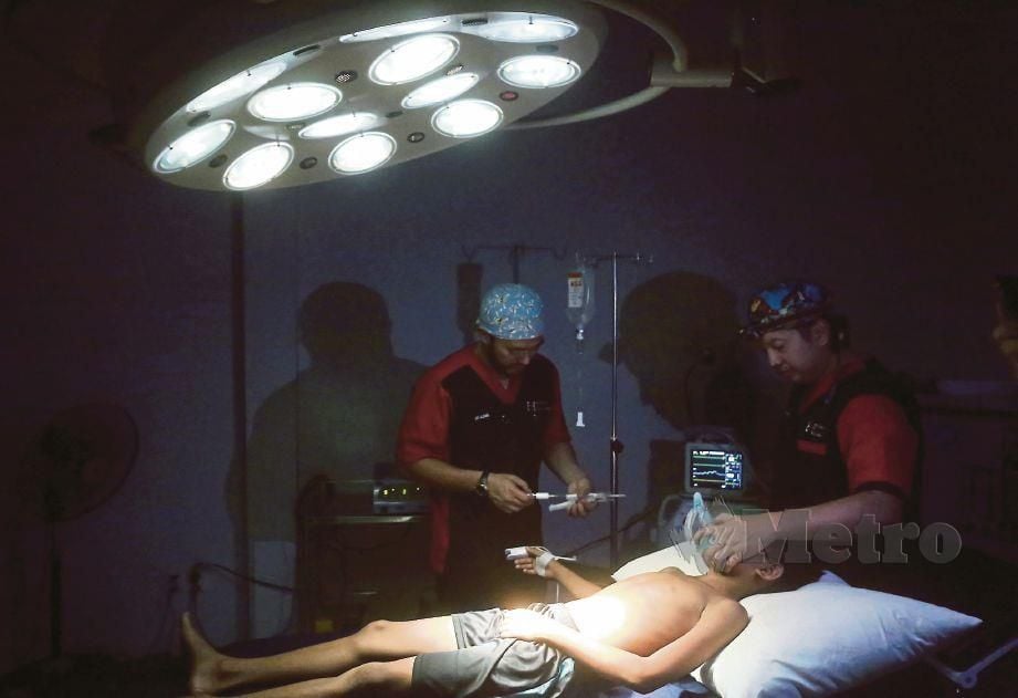 DOKTOR sukarelawan bertungkus lumus menjalankan pembedahan dalam keadaan gelap akibat kekurangan tenaga elekrik ke atas pesakit hernia dalam misi Muslim Care di Chrang Chomres, Phnom Penh, Kemboja. 