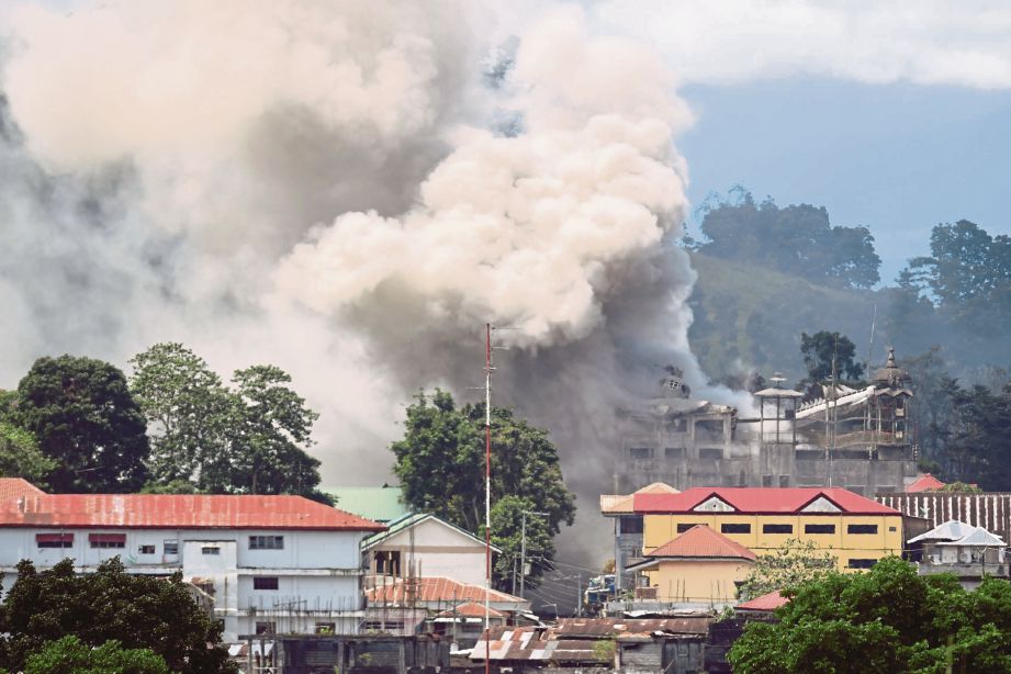 ASAP menjulang ke angkasa dari sebuah bangunan yang terbakar selepas dibom sebuah pesawat tentera Filipina di Marawi baru-baru ini. - AFP