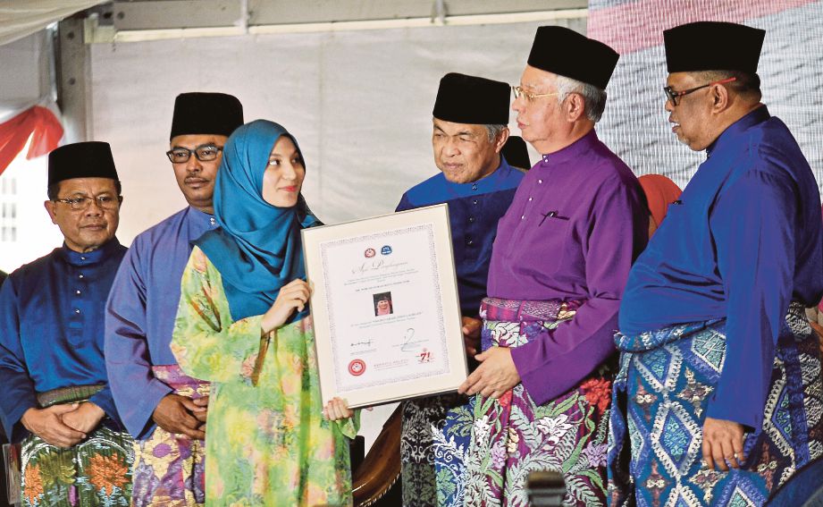   Najib  menyampaikan sijil penghargaan kepada Dr Nor Syahirah, semalam.  