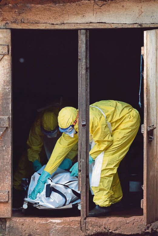 PEKERJA kesihatan Sierra Leone bersiap sedia membawa mayat mangsa Ebola keluar dari sebuah rumah di Freetown untuk dikebumikan.