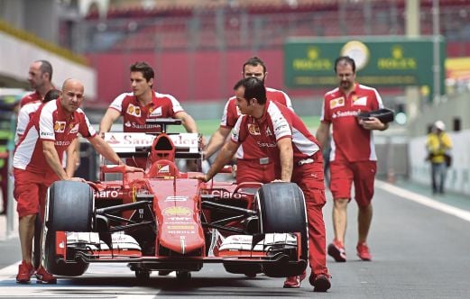 KREW pasukan Ferrari menolak kereta Sebastian Vettel di Interlagos.