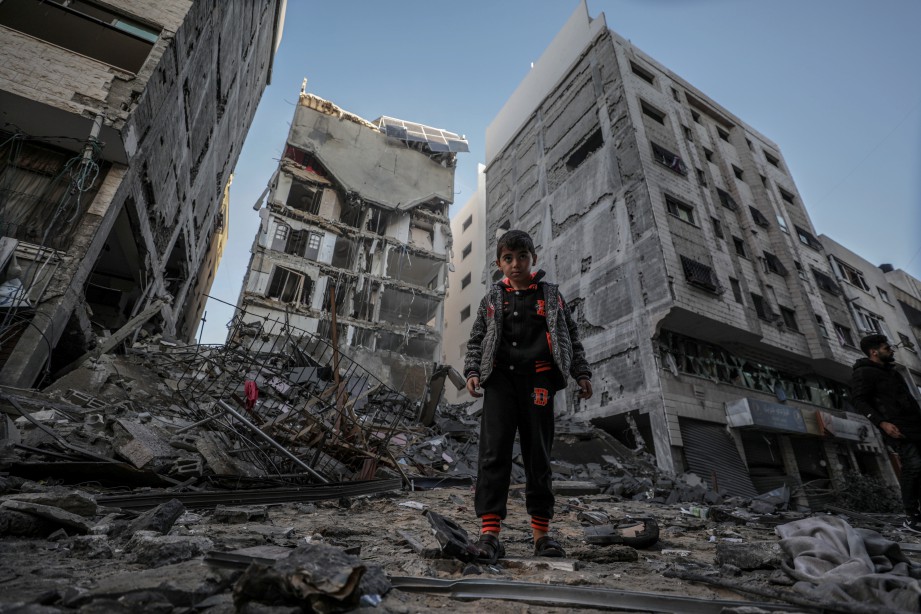 SEORANG budak lelaki melihat kerosakan pada bangunan kediaman akibat serangan udara Israel. - EPA