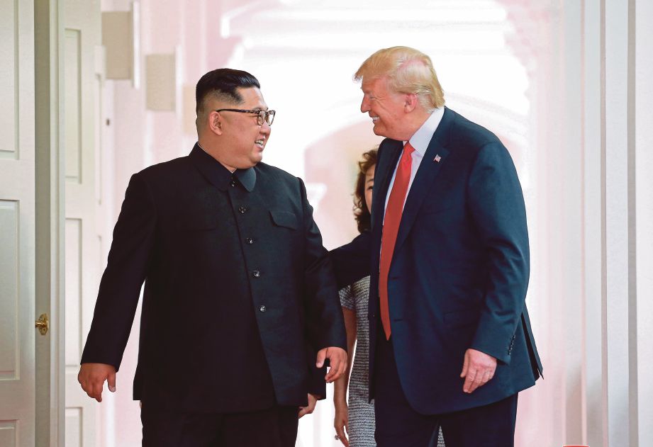 TRUMP (kanan) berbual mesra dengan Jong-un ketika pertemuan kedua-dua pemimpin itu di Singapura kelmarin. - KCNA 