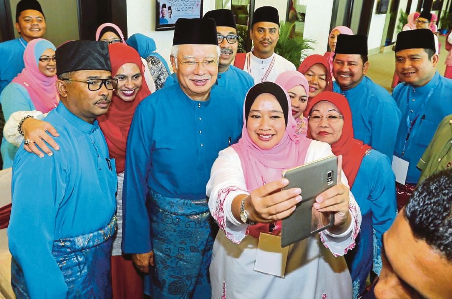 Najib diiringi Idris  (kiri)  bersama Puteri UMNO selepas majlis perasmian Mesyuarat Perwakilan UMNO Bahagian Tangga Batu  di Banda Hilir, Melaka, semalam.