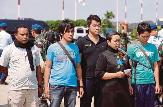 RETNO bercakap kepada wartawan selepas menyambut kepulangan empat kru kapal Indonesia (belakang) yang dibebaskan Abu Sayyaf, di Jakarta, semalam. 