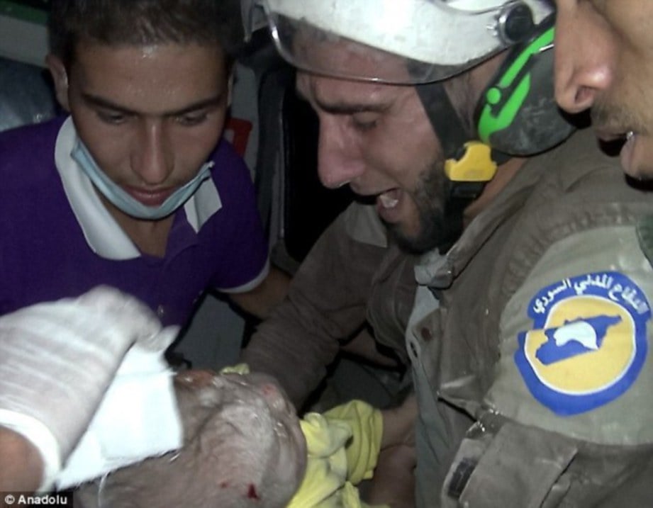 GAMBAR fail, Abu Kifah (kanan) bersama bayi yang diselamatkan dari celah runtuhan bangunan  Oktober lalu.  - Agensi 