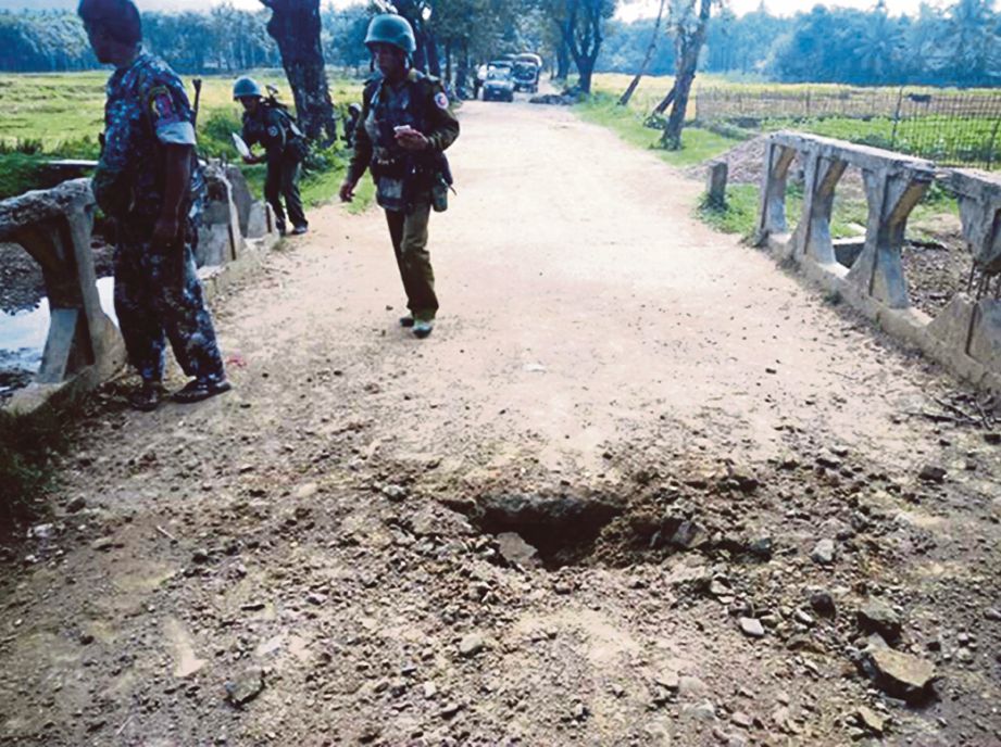 GAMBAR yang diedarkan tentera Myanmar semalam menunjukkan lubang besar akibat letupan periuk api di atas jambatan di kampung Maung Nama Taung di Maungdaw, Rakhine.  - AFP