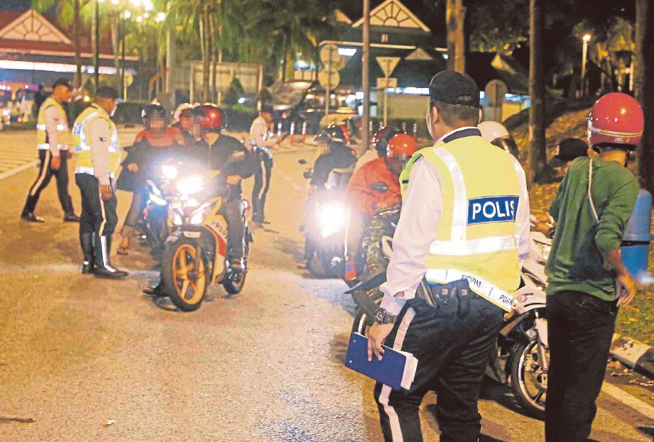 Anggota polis trafik memeriksa sebahagian penunggang motosikal ketika Op Bersepadu Had Laju dan Pelbagai di Plaza Tol Jalan Duta.