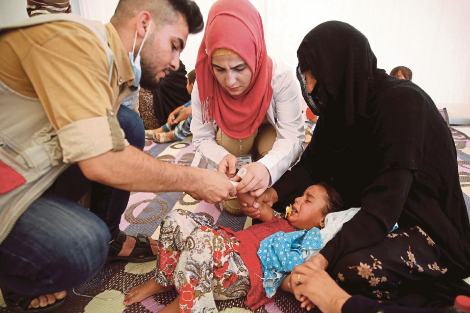 SEORANG pelarian kanak-kanak dirawat di hospital terbuka di timur Mosul selepas mengalami keracunan makanan, kelmarin.  - Reuters 
