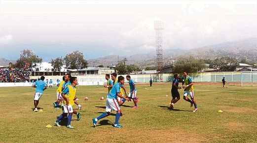 SKUAD negara memanaskan badan sebelum perlawanan di Stadium Perbandaran Dili. 