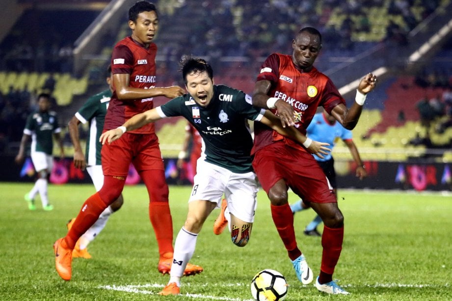 PEMAIN Melaka United, Woo Young Jeon (tengah) cuba melepasi kawalan pemain PKNP FC, Franklin Anzite (kanan) pada aksi Liga Super di Stadium Hang Jebat, Krubong. - Foto Muhammad Zuhairi Zuber