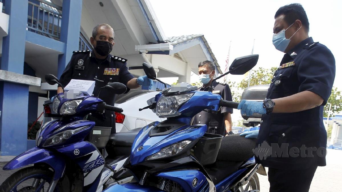 NOORZAINY (kiri) menunjukkan motosikal yang dirampas. FOTO Danial Saad