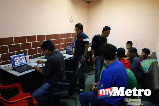 ANGGOTA polis memeriksa komputer riba yang dirampas. FOTO Zainuz Fitri