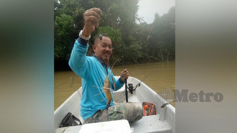 YAHYA menunjukkan udang galah yang dipancingnya di Sungai Sembrong, semalam. FOTO ihsan pembaca