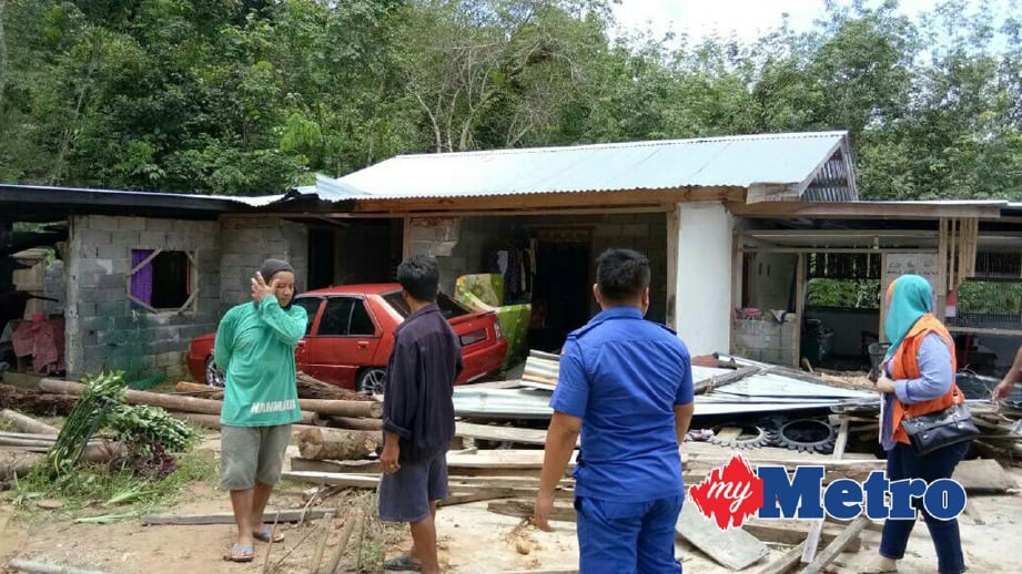 ANGGOT APM dan pegawai Jabatan Kebajikan Masyarakat memeriksa keadaan rumah Jimlee yang terjejas akibat tanah runtuh. FOTO  Rafiqah Dahali