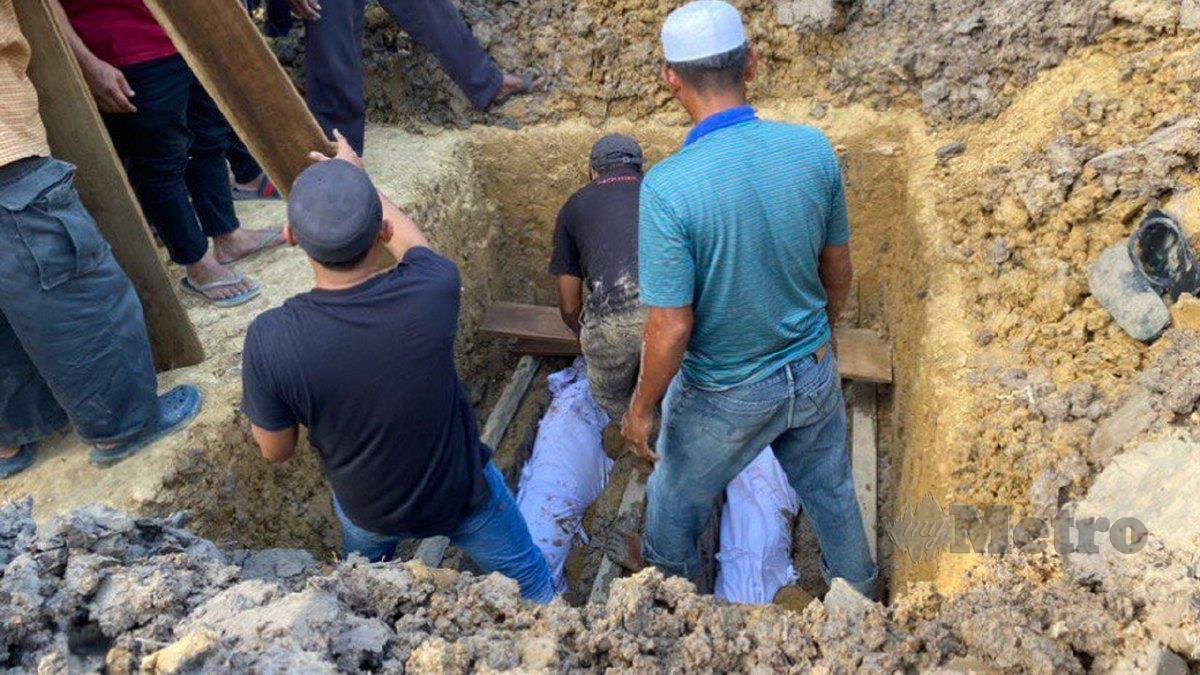 JENAZAH Indok Akok dan Tahallah dikebumikan dalam satu liang di Tanah Perkuburan Islam Kampung Parit Kerimun. FOTO  Togi Marzuki