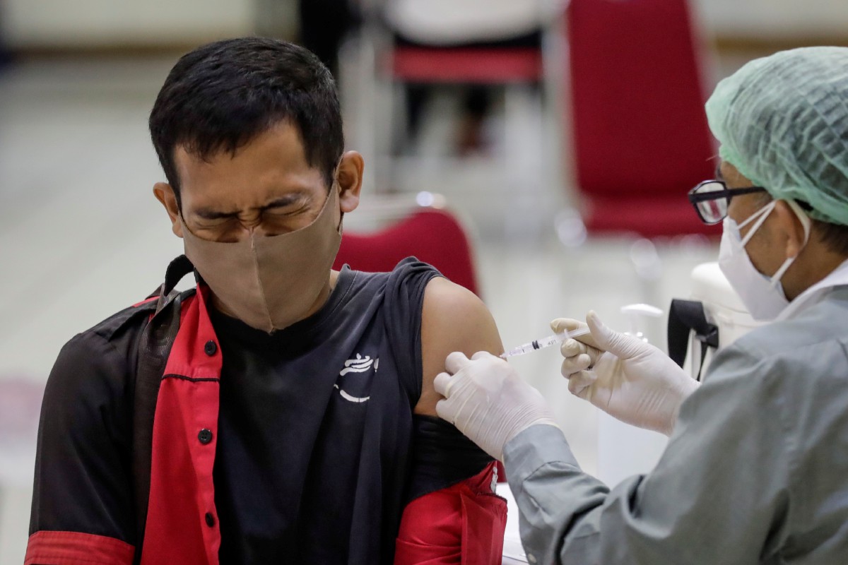 LELAKI menerima suntikan vaksin AstraZeneca di sebuah stadium di Jakarta. FOTO EPA 