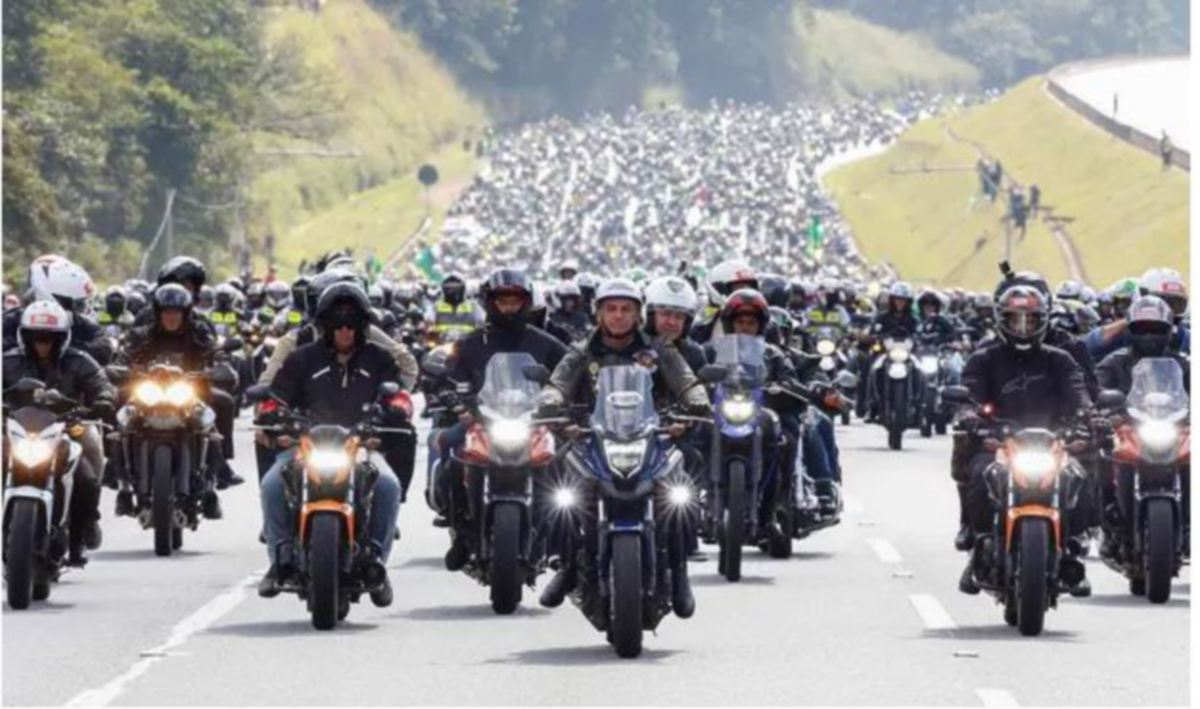 BOLSONARO (tengah) menunggang motosikal bersama-sama penyokongnya. FOTO EPA 