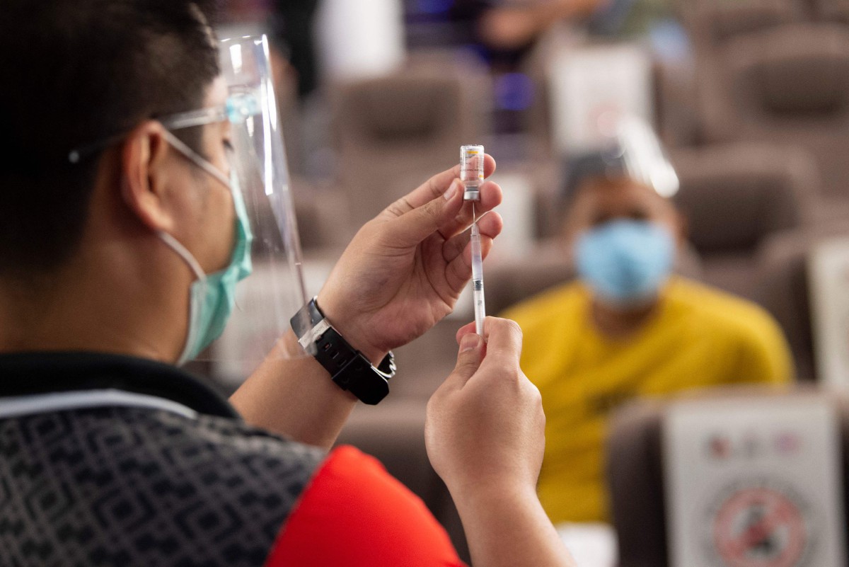 PETUGAS kesihatan menyediakan dos suntikan vaksin COvid-19 Sinovac di salah satu pusat vaksinasi di Manila. FOTO AFP  